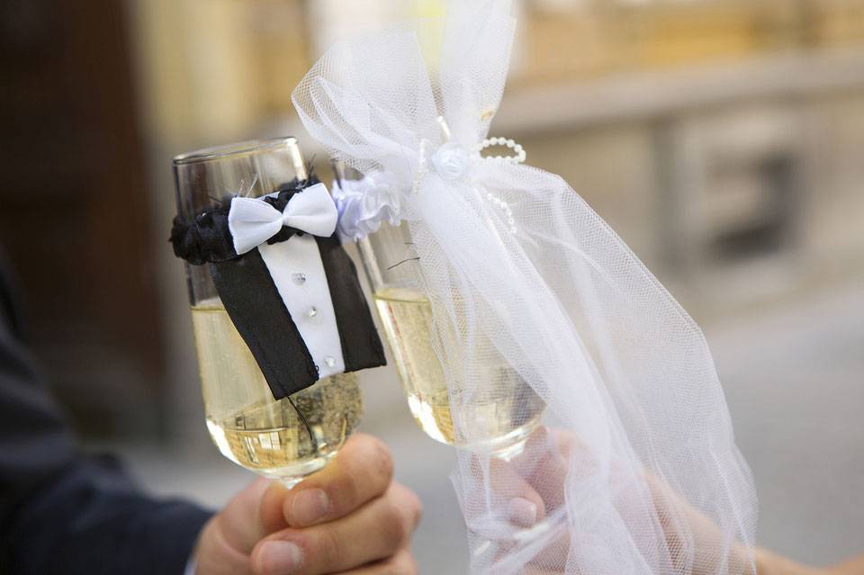 Braut und Bräutigam stoßen nach Budgetplanung mit Sektgläsern an